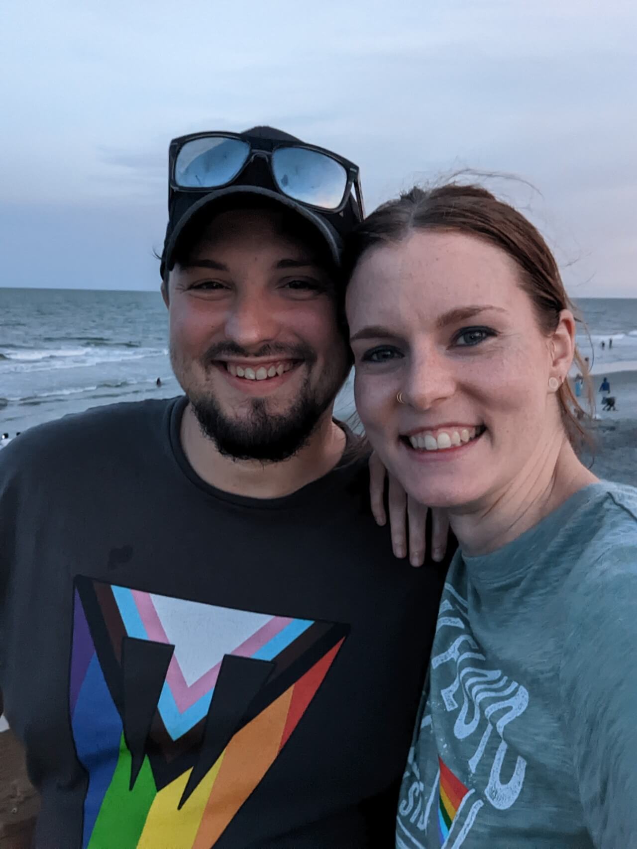 Preston and his wife standing in front of the beach